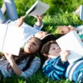 Des enfants lisent dans l'herbe